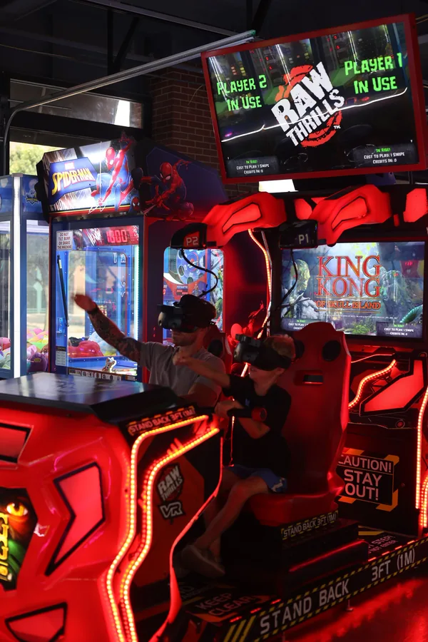 Kids playing a racing arcade cabinet at Brickopolis