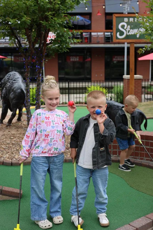 Two kids with putters on the Brickopolis mini golf course